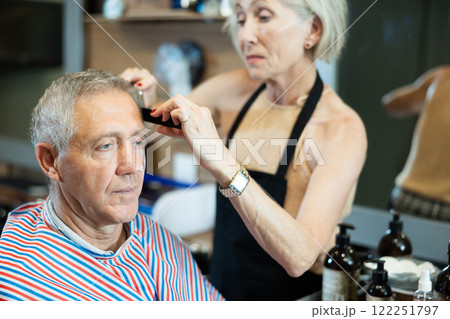 Female hairdresser working with client in barbershop Female hairdresser working with client in barbershop 122251797