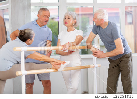 Elderly ballet lovers communicate with each other during break between classes in choreographic studio Elderly ballet lovers communicate with each other during break between classes in choreographic studio 122251810