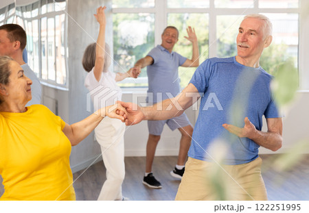 Senior man enjoying vigorous dance with female partner Senior man enjoying vigorous dance with female partner 122251995