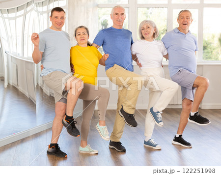 Positive adults forming line while rehearsing celtic dances in dance studio 122251998