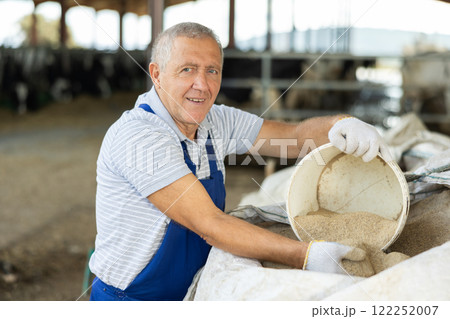 Elderly man scooping sand from bag Elderly man scooping sand from bag 122252007