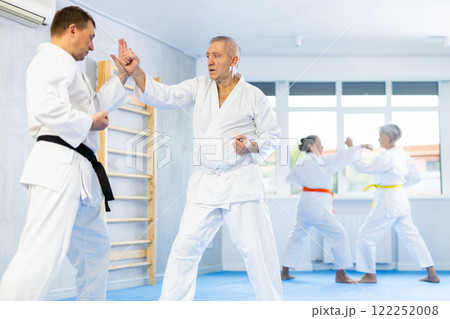 Senior karate practitioner engage in fierce fight oriental single combat Senior karate practitioner engage in fierce fight oriental single combat 122252008