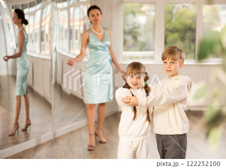 Boy and girl in sport wear train to dance contemporary vigorous rumba during classes. 122252100