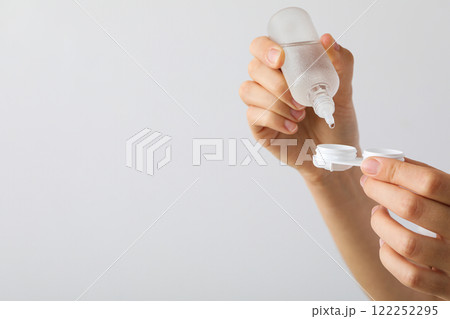 Contact lens liquid with lens container in hand Contact lens liquid with lens container in hand 122252295