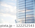 青空を反射する高層ビルの窓 122252543