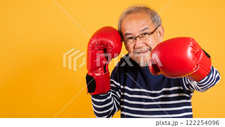 Portrait Asian old man wearing glasses wear two red boxing gloves studio shot isolated yellow background, smiling happy elderly man gray haired healthy fighter lifestyle concept Portrait Asian old man wearing glasses wear two red boxing gloves studio shot isolated yellow background, smiling happy elderly man gray haired healthy fighter lifestyle concept 122254096