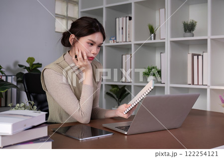 Asian female student studying online Video calls through Zoom about business administration and accounting subjects attentively 122254121