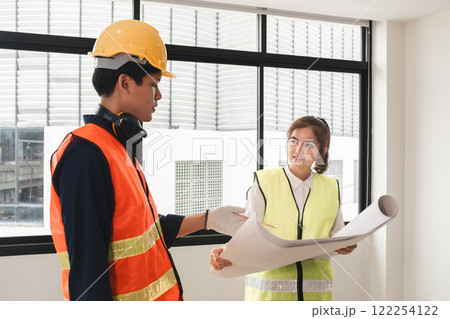 The female foreman discusses with the engineering team about the construction project plans and plans. The female foreman discusses with the engineering team about the construction project plans and plans. 122254122