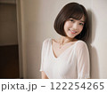 壁に寄りかかりこちらを見ている女性 122254265