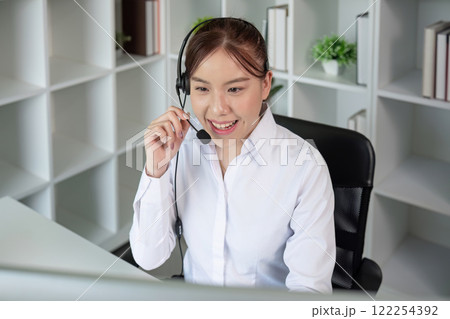 Call center agents wear headphones to talk to customers. Provide consultation via online channels on laptops 122254392