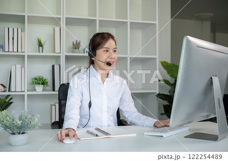 Call center agents wear headphones to talk to customers. Provide consultation via online channels on laptops 122254489