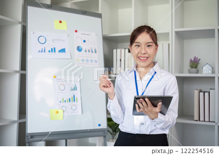 Businesswoman with presentation board at a meeting about work plans Finance and business results graphs Businesswoman with presentation board at a meeting about work plans Finance and business results graphs 122254516