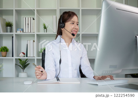 Call center agents wear headphones to talk to customers. Provide consultation via online channels on laptops 122254590