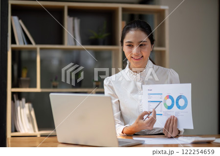 Successful Asian business woman Sit and work with numbers and graph. Over the laptop on the desk in the office 122254659