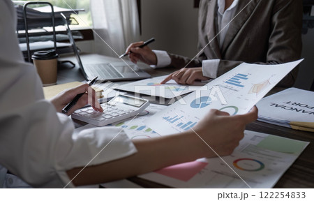 Close-up, A team of accountants and businesswomen sit and work on numbers and graphs. On the laptop on the table in the office 122254833