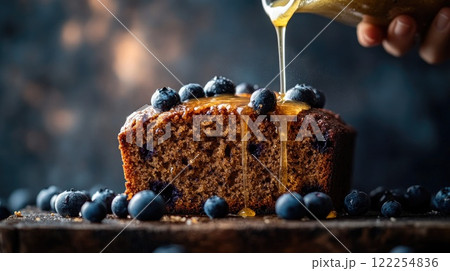 Blueberry loaf cake drizzled with honey and surrounded by fresh blueberries in a rustic setting 122254836
