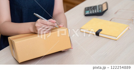 Online product entrepreneurs write parcel boxes to prepare for shipping. 122254889