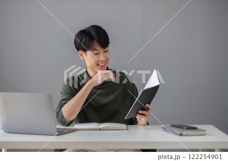 Portrait of a handsome young office worker intently studying how to do a presentation project on a laptop in his office. 122254901
