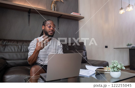 Young African American businessman spends his free time working from home on his laptop. 122255045