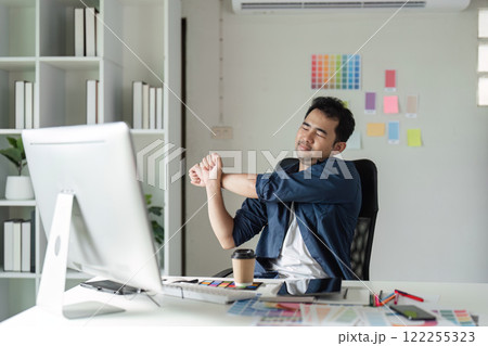 Young Designer Experiencing Pain While Working at Desk in Modern Office Environment with Computer and Creative Tools Young Designer Experiencing Pain While Working at Desk in Modern Office Environment with Computer and Creative Tools 122255323