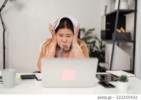 Stressed Businesswoman Overwhelmed with Workload in Modern Office Setting Stressed Businesswoman Overwhelmed with Workload in Modern Office Setting 122255432