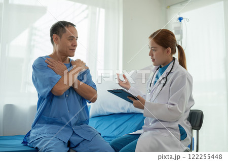 A female doctor is examining the body and taking notes on a sick person in a hospital examination room. A female doctor is examining the body and taking notes on a sick person in a hospital examination room. 122255448