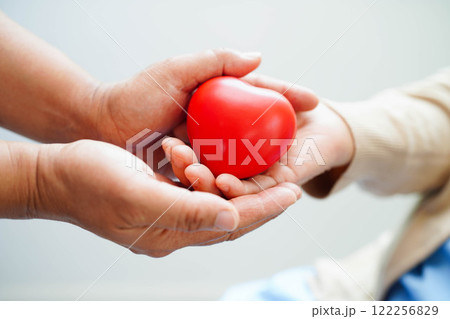 Asian elder senior woman patient holding red heart in hospital. 122256829