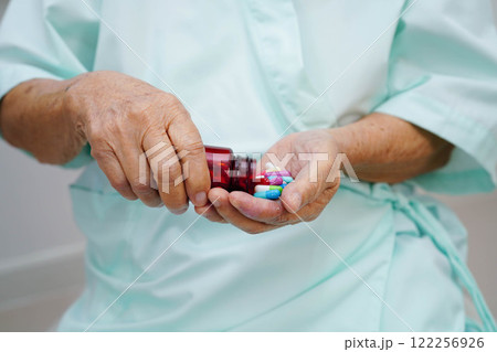 Asian elderly woman holding pill drug in hand, strong healthy medical. 122256926