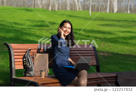 asian girl use laptop to work from everywhere at public park with wireless technology in new behavior of worker asian girl use laptop to work from everywhere at public park with wireless technology in new behavior of worker 122257832