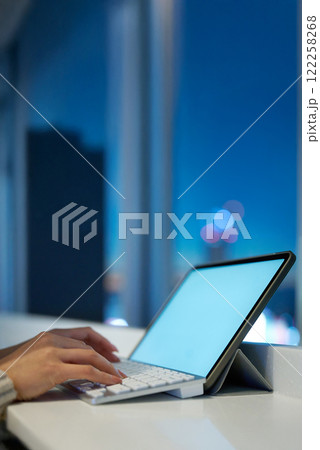 夜景の見える空間でパソコンのキーボードをタイプする手元 夜景の見える空間でパソコンのキーボードをタイプする手元 122258268