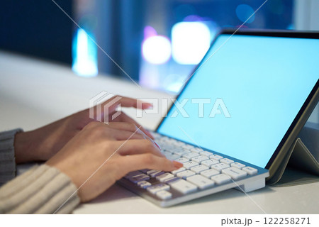 夜景の見える空間でパソコンのキーボードをタイプする手元 夜景の見える空間でパソコンのキーボードをタイプする手元 122258271