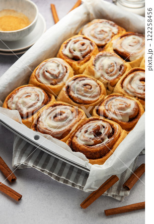 Freshly baked cinnamon rolls drizzled with icing in a baking pan Freshly baked cinnamon rolls drizzled with icing in a baking pan 122258456