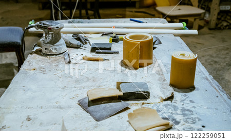 Various tools: file, screwdriver, hammer, pliers, garden tools are displayed on wooden shelf inside rustic garage or manufactory, workshop studio in a rustic garden house. Hobby, leasure activity 122259051