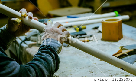 carpenter using nail gun or brad nailer tool on wood box in a workshop ,furniture restoration woodworking concept. selective focus 122259076
