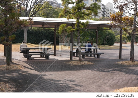 公園の屋根付きベンチで休む人 122259139