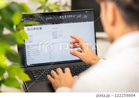 自己申告書を記入する男性 122259804