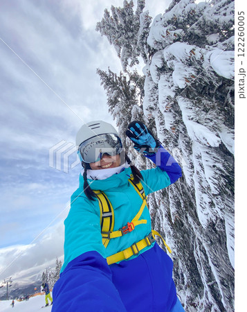 Smiling Woman with Skis on Snowy Slope 122260005