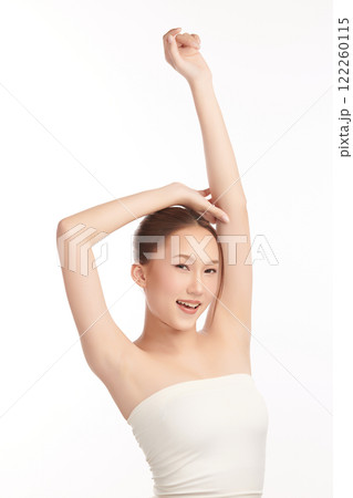 Beautiful Young Asian woman lifting hands up to show off clean and hygienic armpits or underarms on white background, Smooth armpit cleanliness and protection concept 122260115