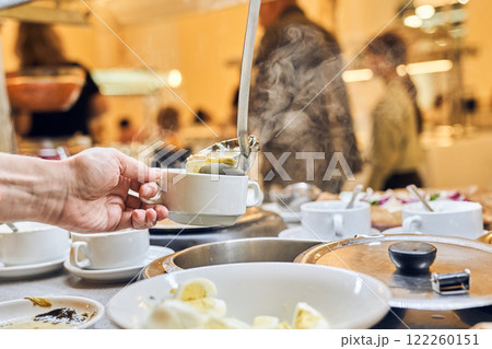 Volunteers distribute hot soup to the homeless at a public charity donation center, a concept for helping people in difficult situations. High quality photo Volunteers distribute hot soup to the homeless at a public charity donation center, a concept for helping people in difficult situations. High quality photo 122260151