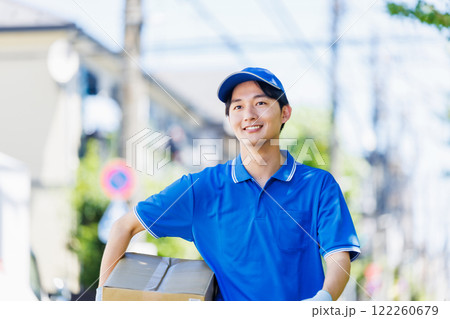 荷物を届ける宅配便の若いドライバー 122260679