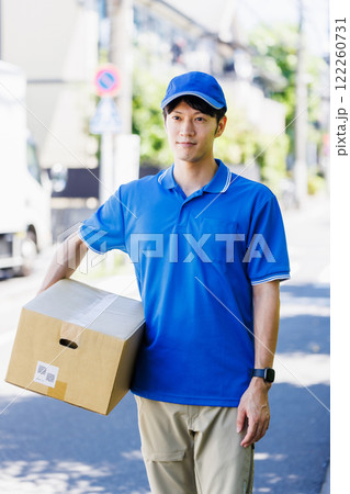 荷物を届ける宅配便の若いドライバーの写真素材 [122260731] - PIXTA