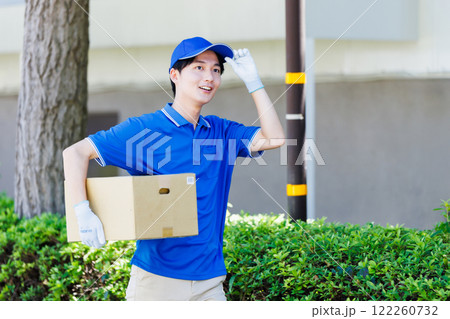 荷物を届ける宅配便の若いドライバー 荷物を届ける宅配便の若いドライバー 122260732