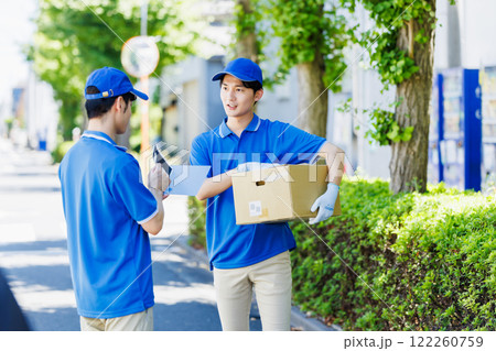 荷物を届ける宅配便の若いドライバー 122260759