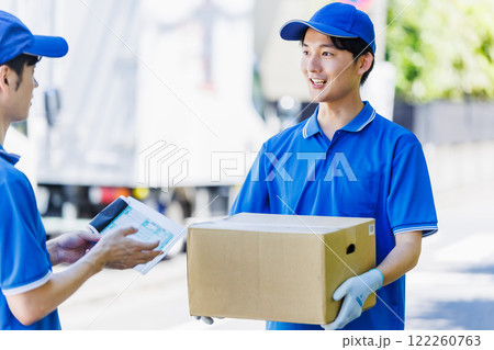 荷物を届ける宅配便の若いドライバー 122260763