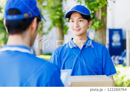 荷物を届ける宅配便の若いドライバー 122260764