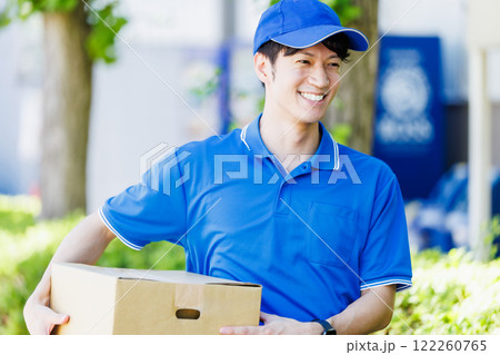 荷物を届ける宅配便の若いドライバー 122260765