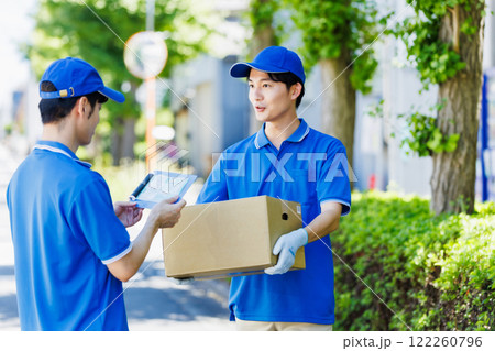 荷物を届ける宅配便の若いドライバー 122260796