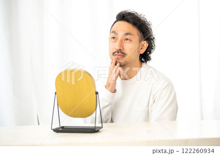 鏡で肌を確認する日本人男性 122260934