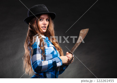 Pretty strong woman in hat holding machete. Pretty strong woman in hat holding machete. 122261455