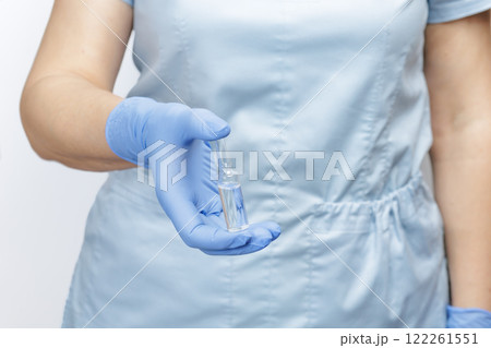Female doctor in gloves holding an ampoule with medicine Female doctor in gloves holding an ampoule with medicine 122261551